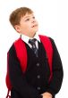 School boy standing and looking up with his backpack.