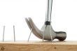 nail being pulled out of wooden plank