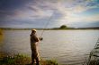 fisher with rod near the river