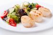 Salad of scallops on a white plate 