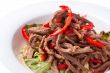 Salad of meat with red pepper on white plate