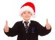 Happy smiling school boy in Santa hat.