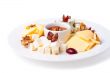 a plate with slices of cheese of different varieties