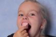 Beautiful small girl eating sweetmeat