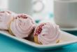 Three cakes with pink cream on a blue background