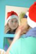 Looking into the mirror - woman with santa hat -