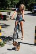Pretty young blonde riding a bicycle.