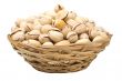 Pistachio nuts in a wicker plate, isolated