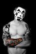 pumped up young man with tattoos and painted face