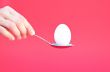 Hand holding an Egg with a Spoon