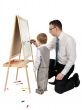 Businessman teaches his son to paint on an easel