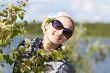 Portrait of a blond girl behind the green bush