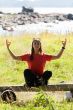 girl in a red dress sitting on a bench in the lotus position