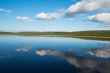 Calm beautiful rural landscape with a lake and sky reflected