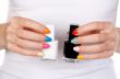 Closeup of a hand holding bottles with two nail polish