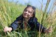 Woman in sunglasses looks through the grass with ears