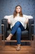 Portrait of a girl in a chair against a background of retro wall