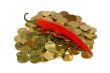 Heap of coins and red hot chili peppers