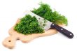 Cutting fresh dill on a cutting board