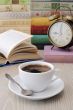 A cup of coffee on a table among books