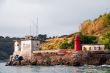 small red lighthouse and old house