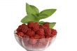 Berries of raspberry in a glass vase with the leaves of mint