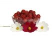 Berries raspberries in a glass vase on a table with flowers