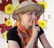 Woman in a hat shows quietly and smiles