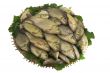 Crucians on a round wattled dish and greens on a white backgroun