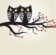 Two cute owls on the tree branch