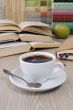 A cup of coffee on a table among books