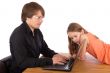Daughter looks at her father`s laptop
