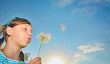 Young girl blowing dandelion
