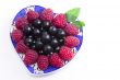 Raspberries and black currant on the beautiful saucer