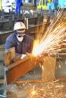 worker using torch cutter to cut through metal