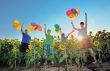 happy childrens jumping on meadow with balloons