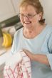 Senior Adult Woman Drying Bowl At Sink in Kitchen