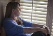 Pensive Woman Sitting Near Window Shades