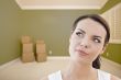 Contemplative Young Woman Daydreaming in Empty Room with Boxes
