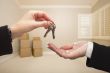 Agent Handing Over the House Keys Inside Empty Tan Room