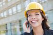 Young Female Contractor Wearing Hard Hat on Site Using Phone