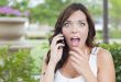 Shocked Young Adult Female Talking on Cell Phone Outdoors