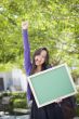 Excited Mixed Race Female Student Holding Blank Chalkboard