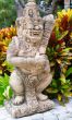 Thai stone god in the bushes of tropical plants