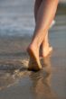 Beautiful woman legs on the beach at sunset