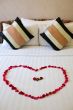 Heart of rose petals laid out on the bed