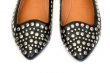 Black women`s leather ballet flats with steel rivets close up 