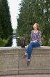 eautiful girl sits on an old stone bridge 