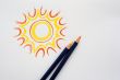 Hand drawing sun with pencils