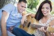 Mixed Race Couple at the Park Playing Guitar and Singing